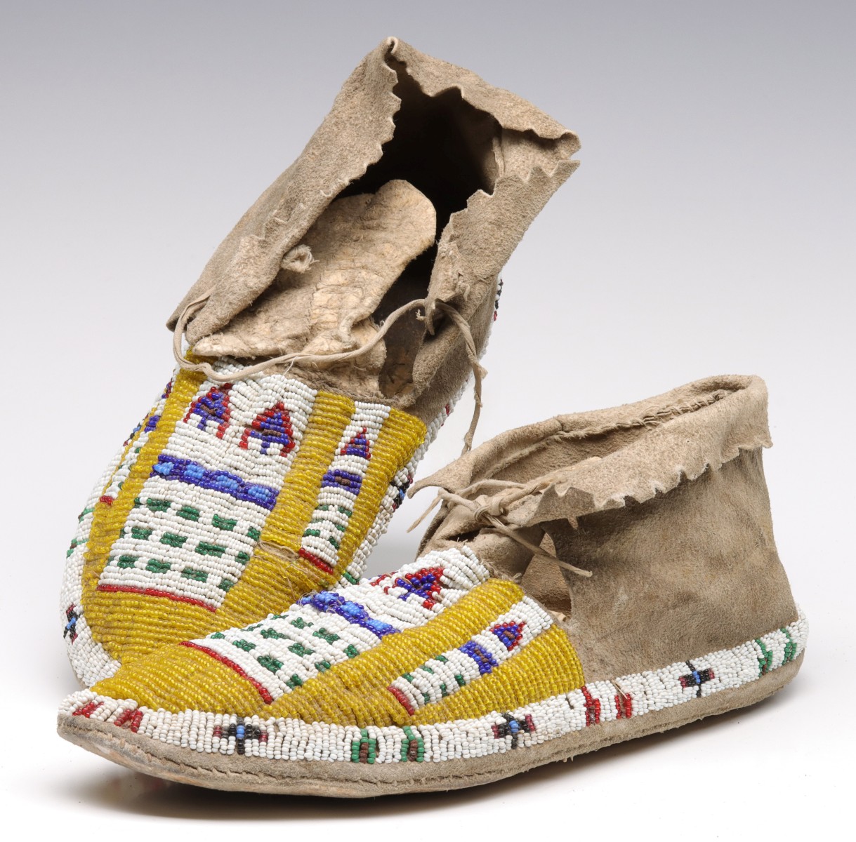 A PAIR CHEYENNE SINEW-SEWN MOCCASINS WITH YELLOW GROUND