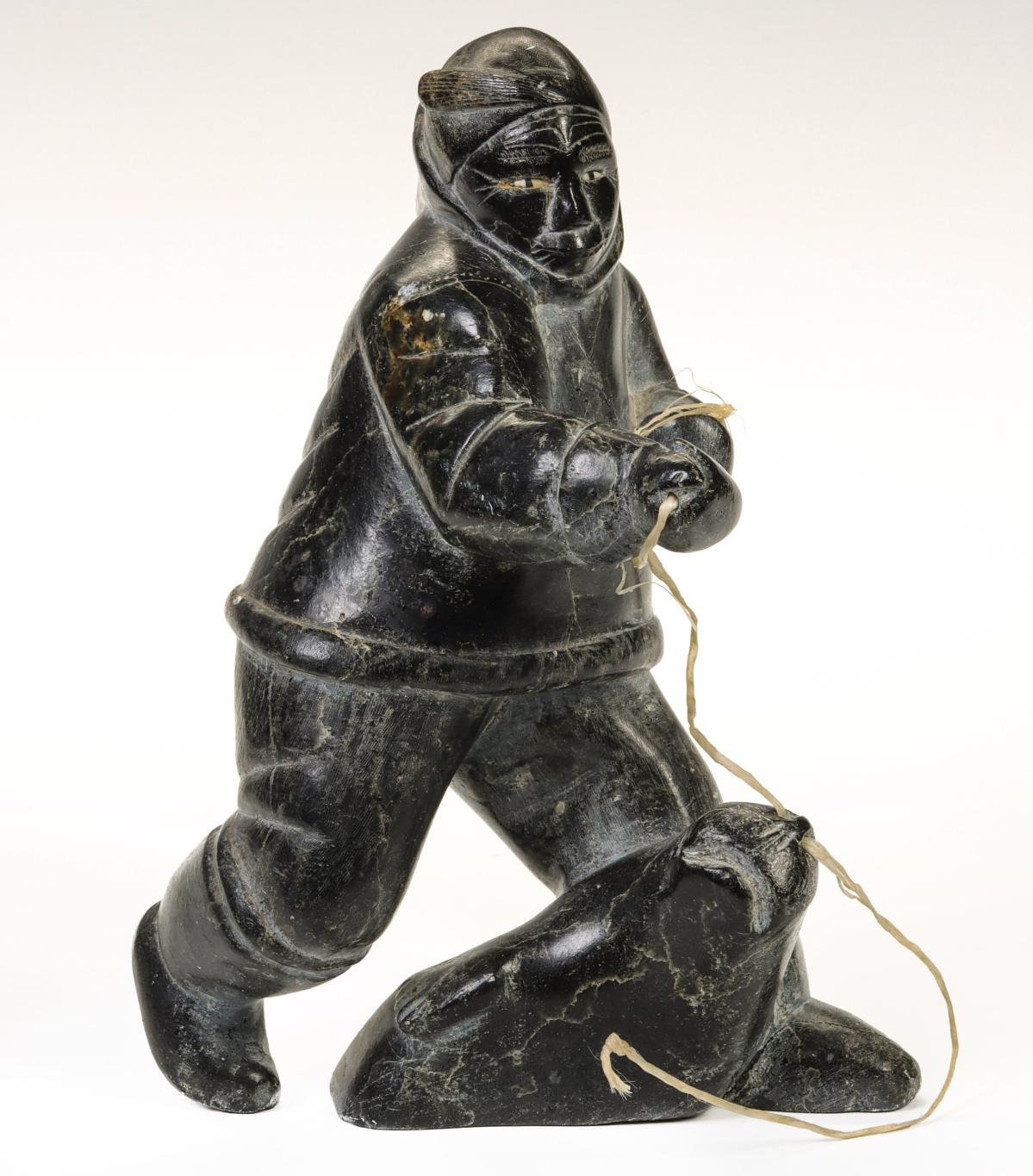 INUIT KEEWATIN STONE CARVING OF A HUNTER W/ INLAID EYES