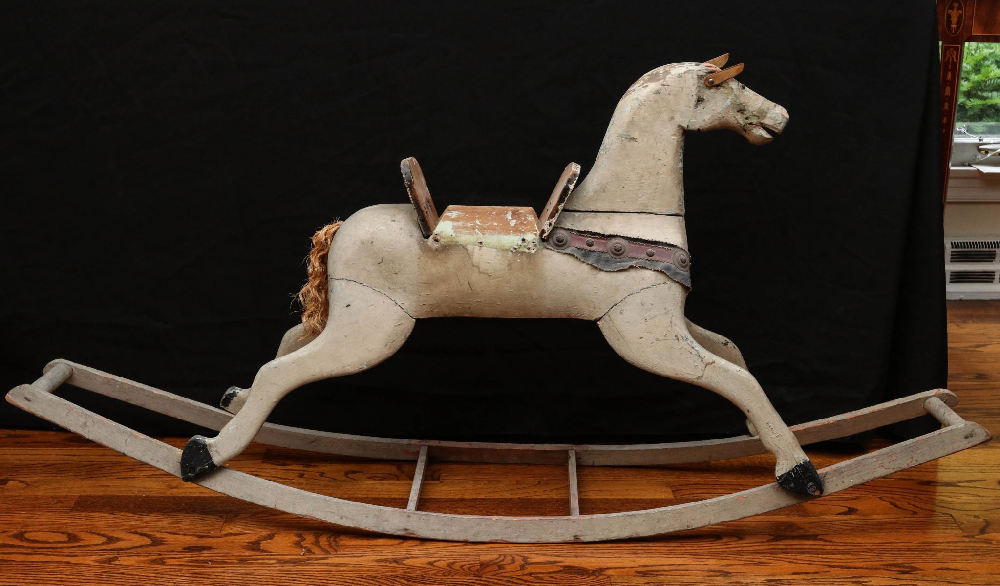 A 19TH CENTURY CARVED AND PAINTED ROCKING HORSE