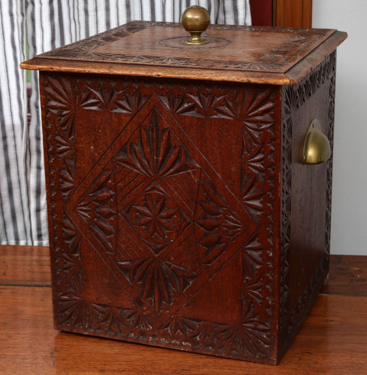 AN ANTIQUE CARVED MAHOGANY KINDLING BOX WITH BRASS