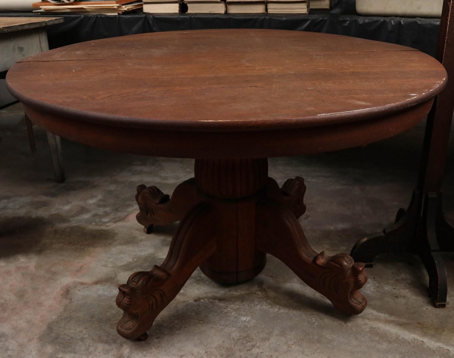 A ROUND OAK TABLE WITH CARVED LION HEAD FEET