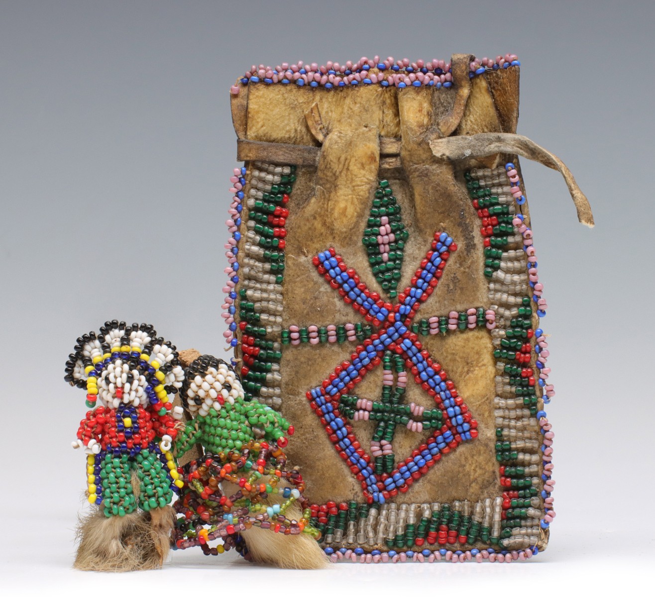A PLAINS BEADED POUCH AND TWO BEADED FETISHES