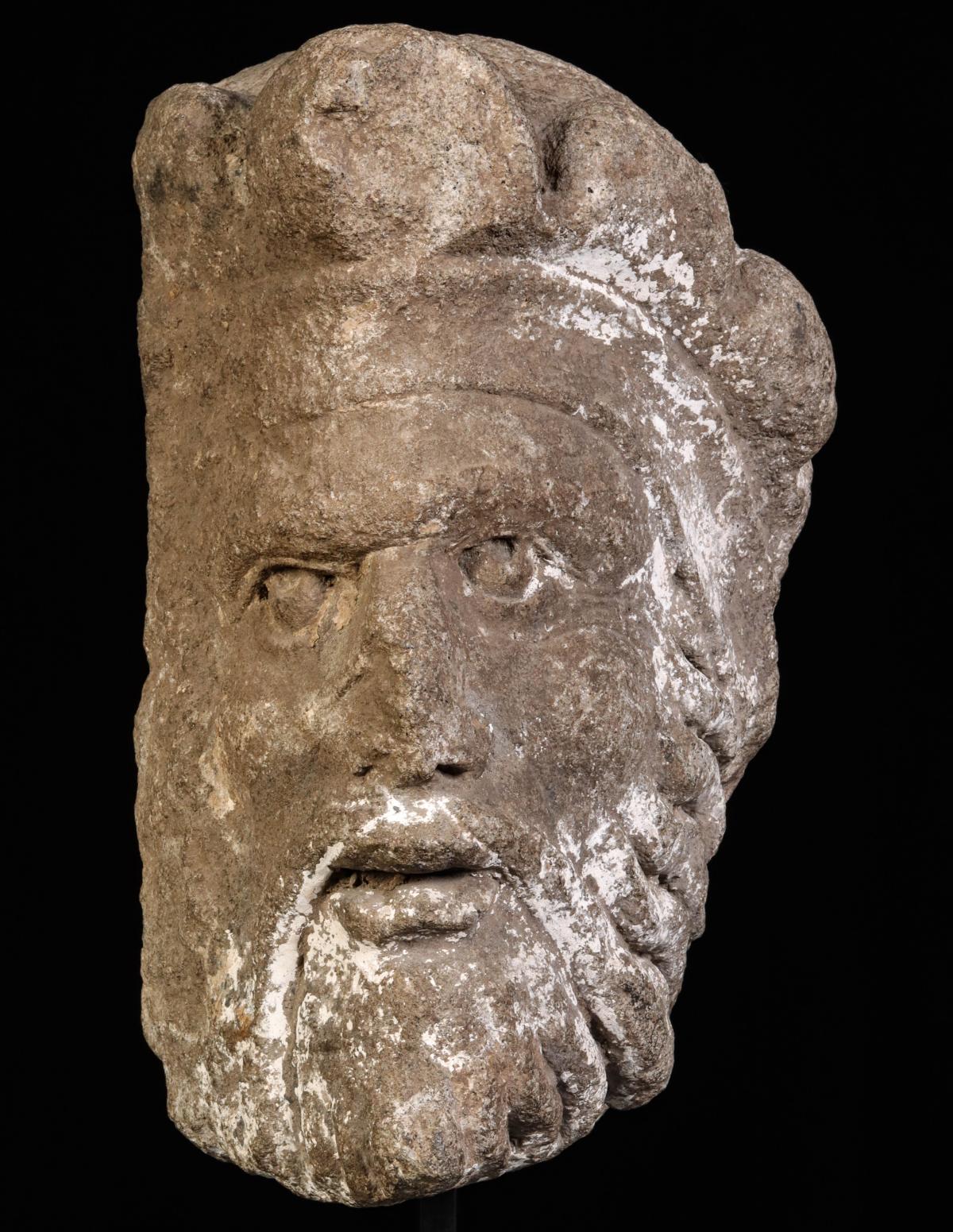 A LARGE CARVED OR CAST STONE HEAD FRAGMENT